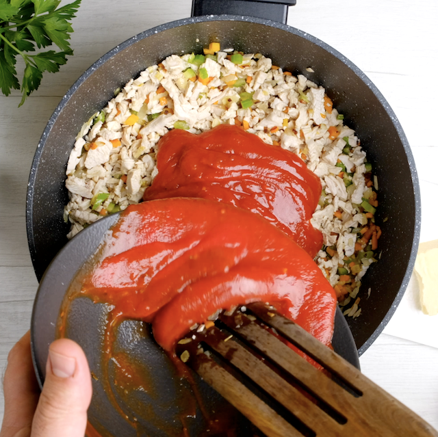Marinara sauce being added to pot to make turkey bolognese at home.