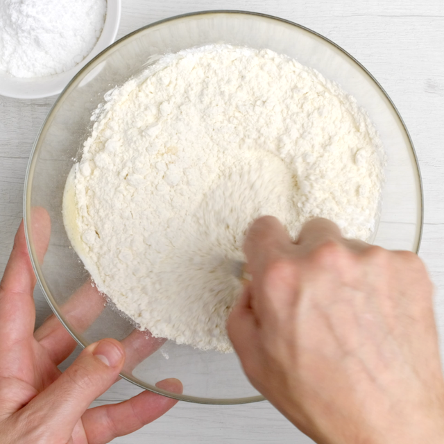 Flour being mixed into cranberry cake batter.