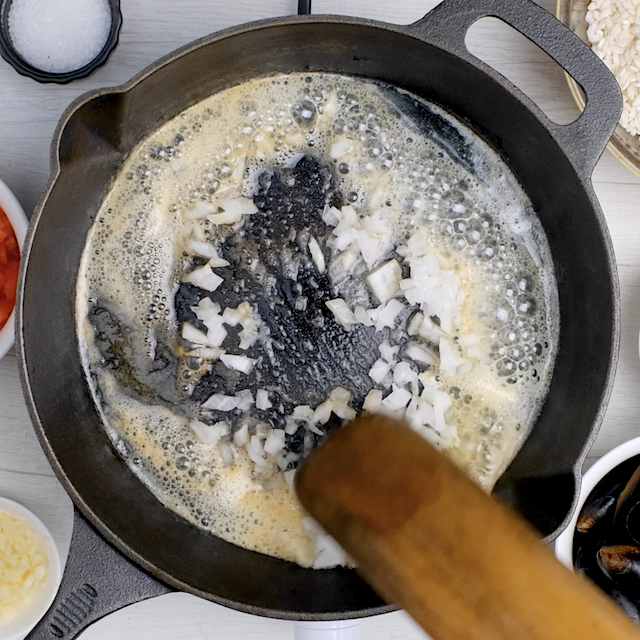 Onions being sautéed in butter to make easy seafood paella.