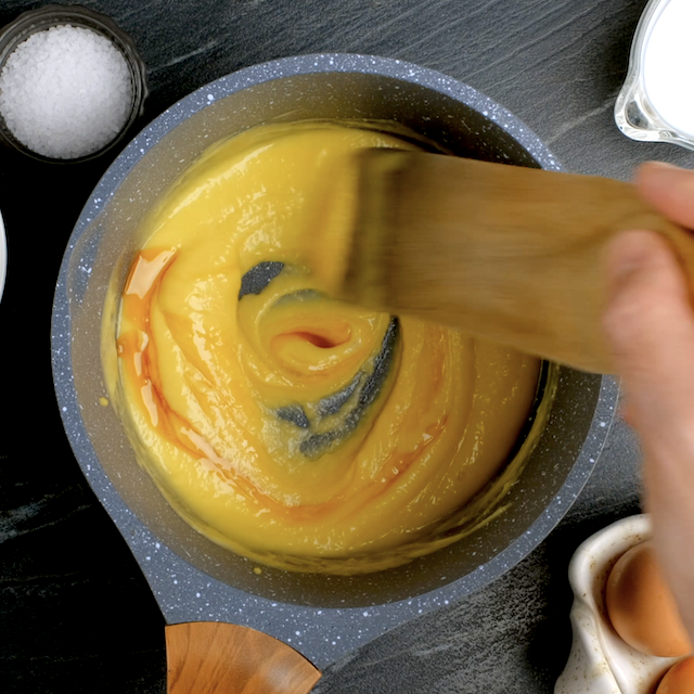 Pastry cream being cooked on a stovetop to make boston cream cupcakes.