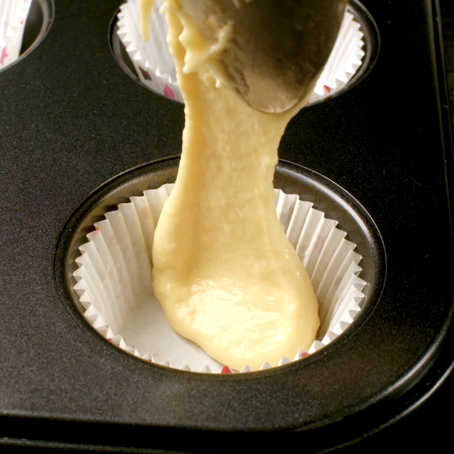 Cupcake liners being filled with batter to make boston cream cupcakes.