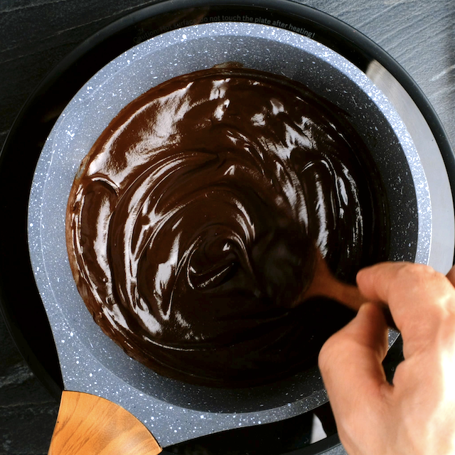 Chocolate glaze being made in saucepan for boston cream cupcakes.