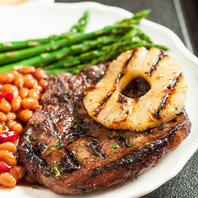 grilled pork chops with pineapple rings on a plate
