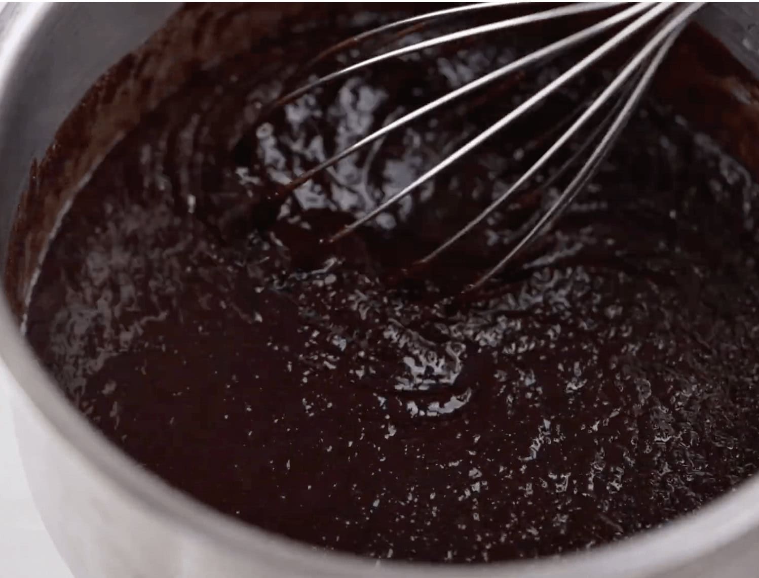 Whisking the chocolate until smooth.