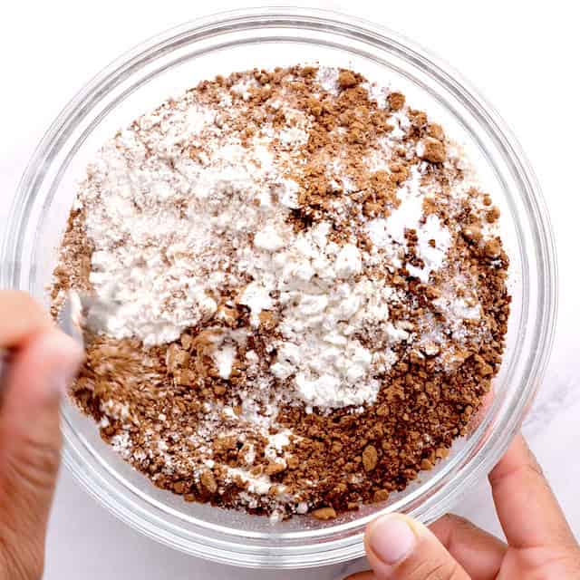Dry ingredients to make chocolate chip zucchini bread being mixed in a glass bowl.