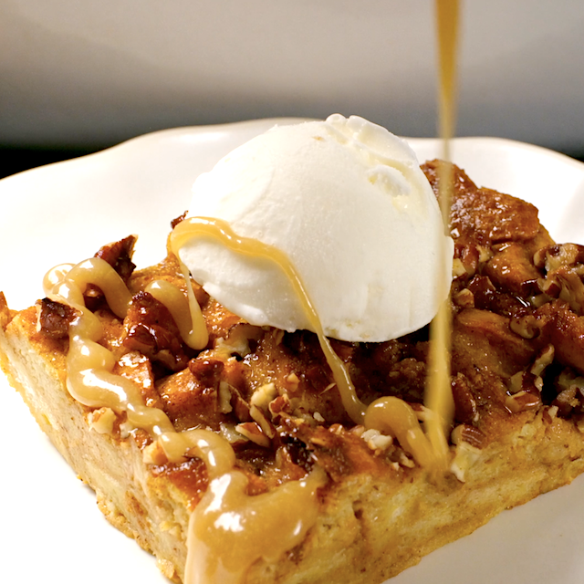 Caramel sauce being drizzle over a slice of pumpkin bread, topped with vanilla ice cream.