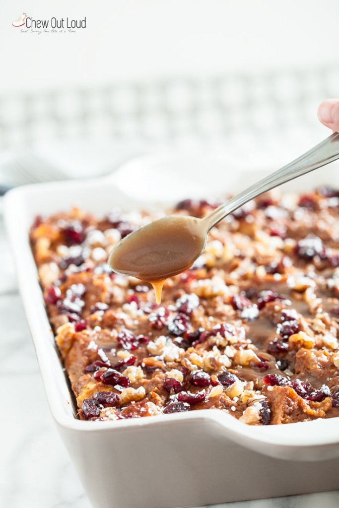 A spoon of caramel with a pan of pumpkin bread pudding
