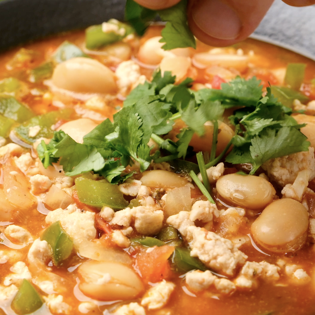 White bean turkey chili being served with cilantro on top.