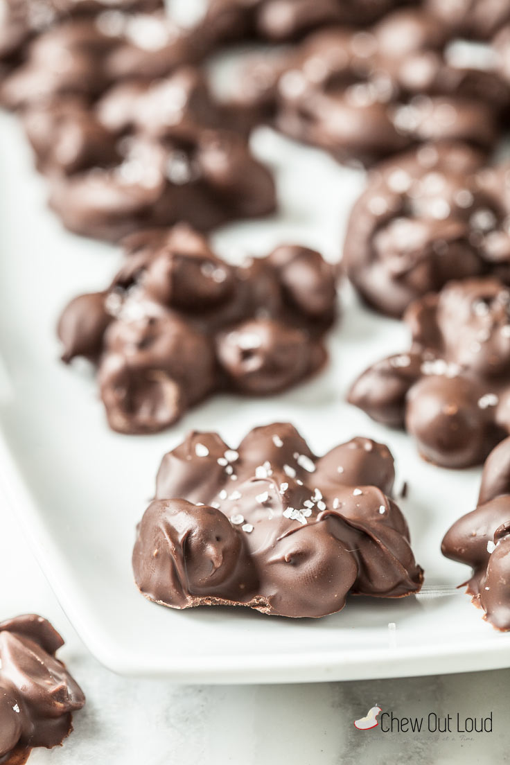 chocolate almond clusters with sea salt on a white plate
