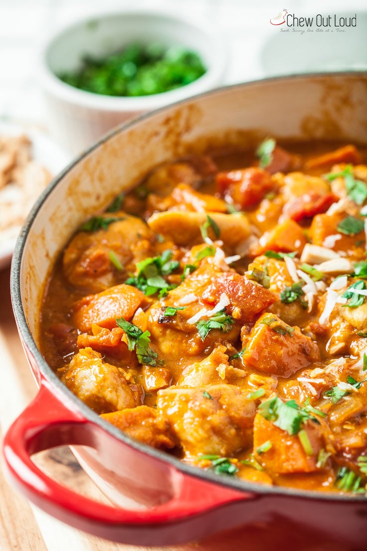 chicken stew with sweet potatoes in dutch oven and garnishes