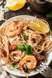 Shrimp scampi pasta with linguini, shrimp, and basil on a plate.