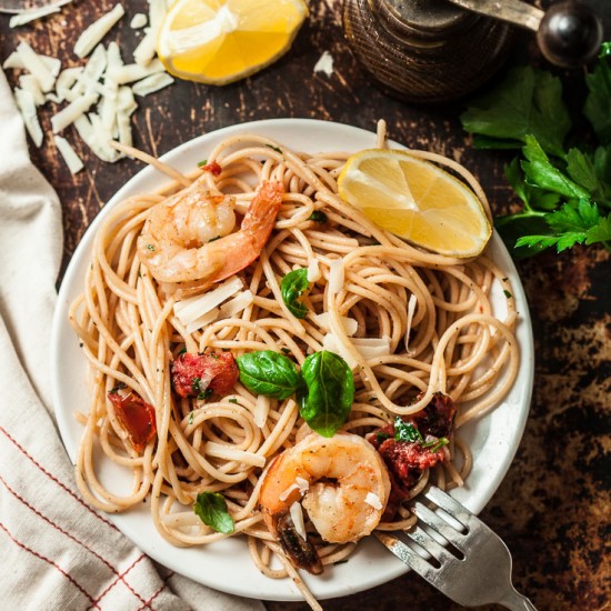 Shrimp scampi pasta with linguini, shrimp, and basil on a plate.