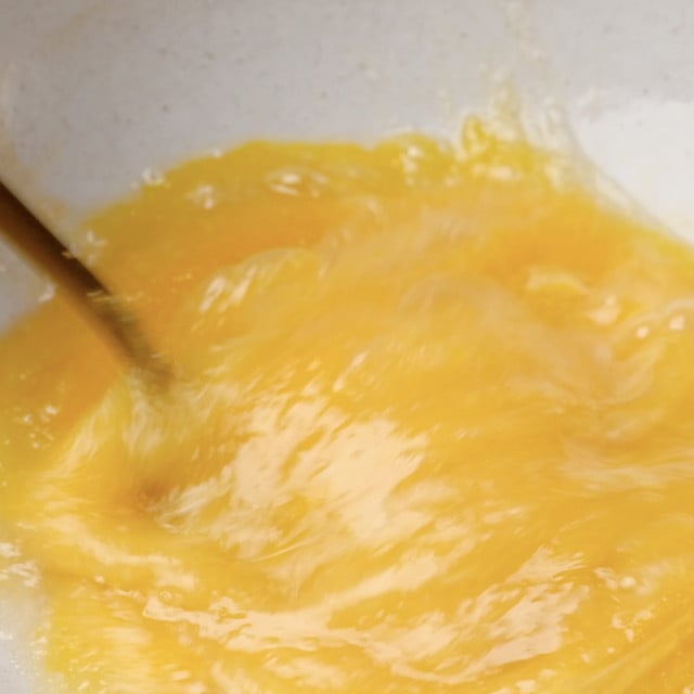 Eggs and sugar being whisked together to make chewy brownie cookies.