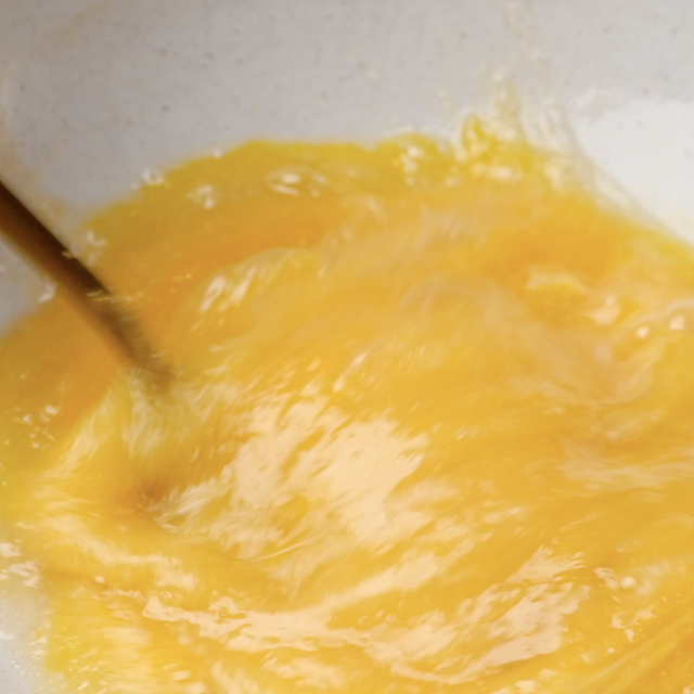 Eggs and sugar being whisked together to make chewy brownie cookies.