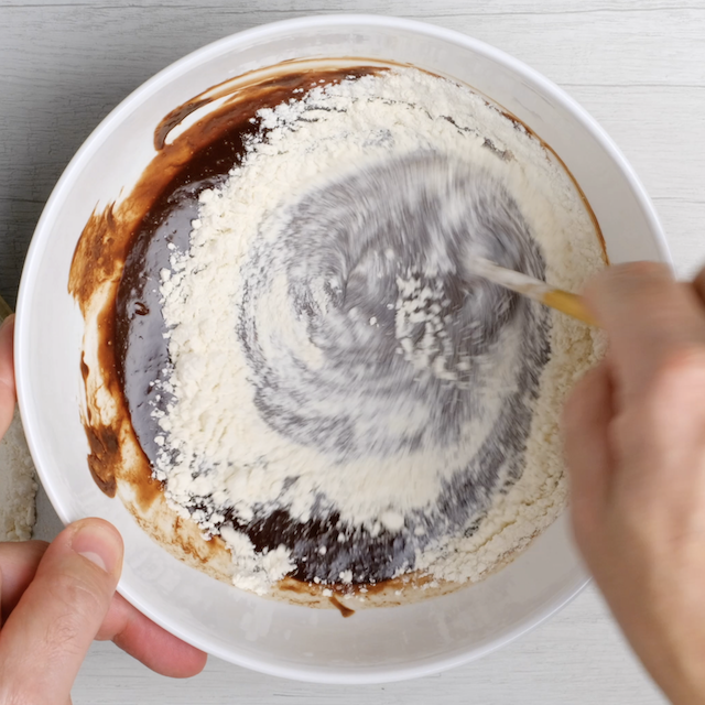 Flour being folded into chocolate-egg mixture.