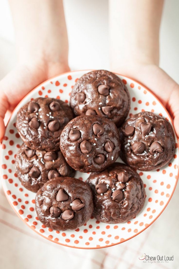 chocolate brownie cookies on a round plate being held out by two hands