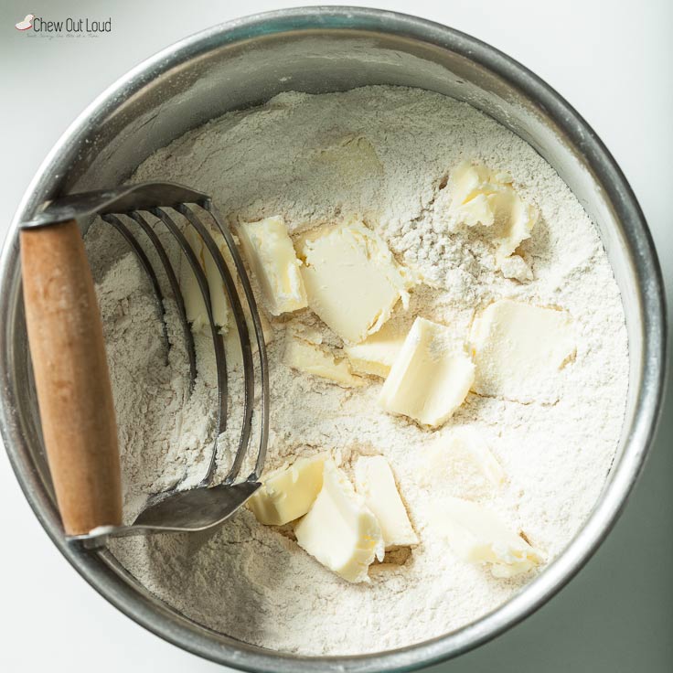 flour and butter being cut into it in a bowl