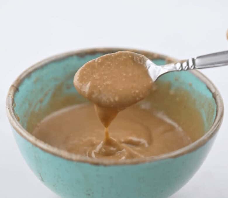 Mixing together the peanut sauce ingredients with a spoon.
