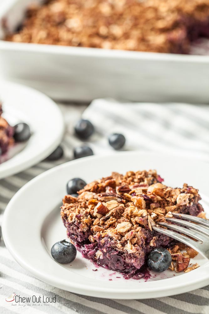 Slice of healthy blueberry crumble on plate with fork