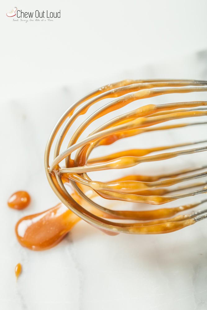 Homemade caramel sauce on a whisk