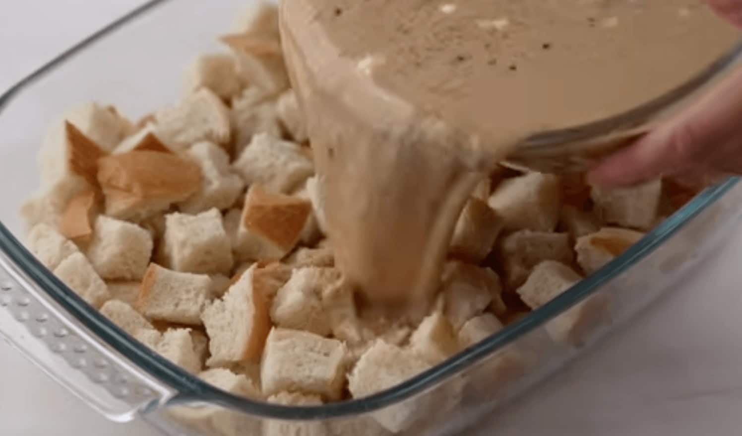 Mixing together the egg mixture and batter ingredients to pour over the bread cubes.