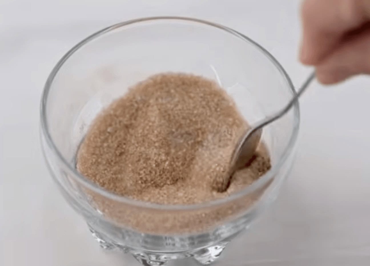 Mixing the French Toast Casserole topping ingredients in a small bowl, using a spoon.