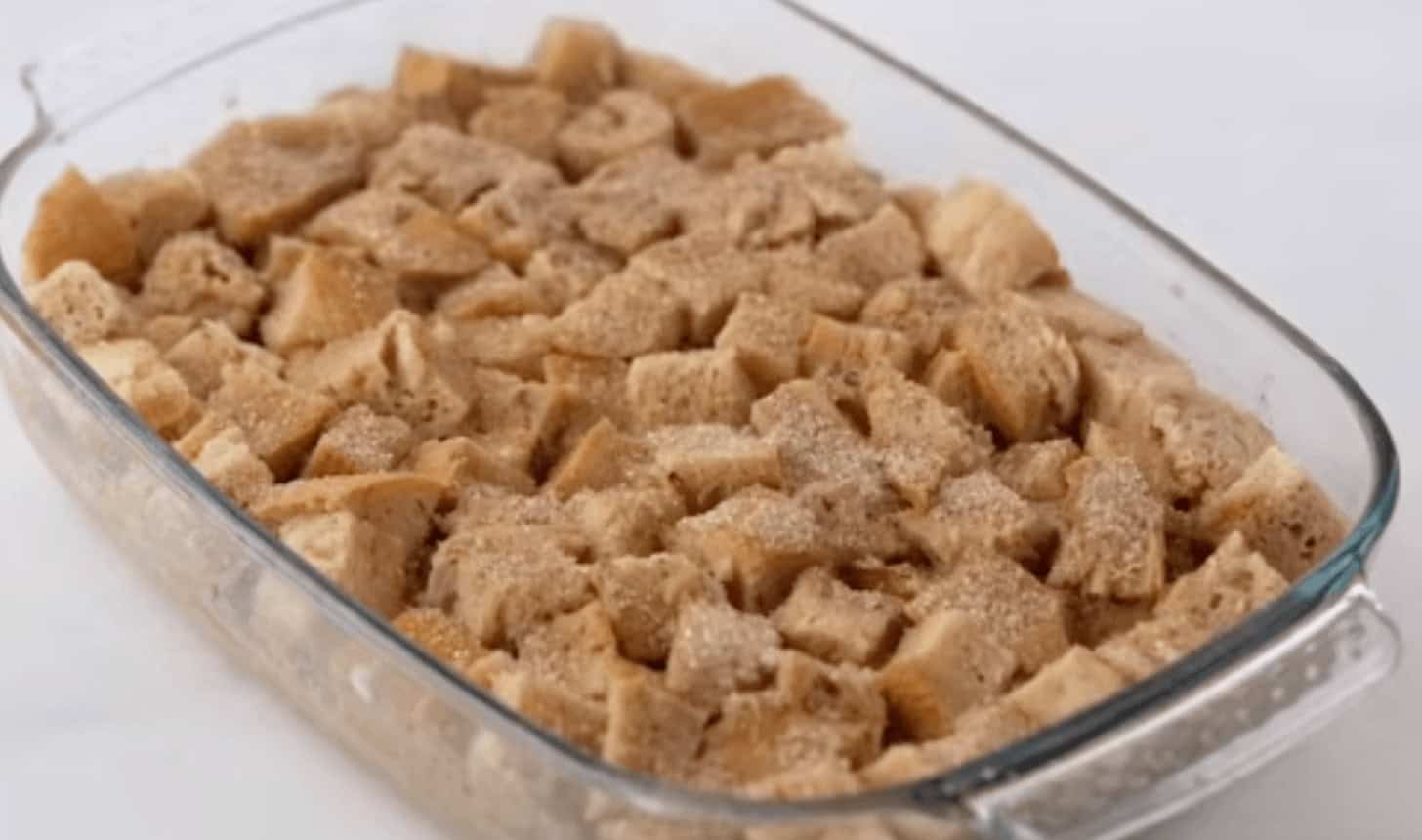 Adding the sugar topping onto the baked bread cubes.