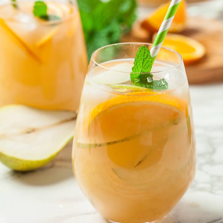 ginger pear sangria cocktail in glasses with mint sprigs