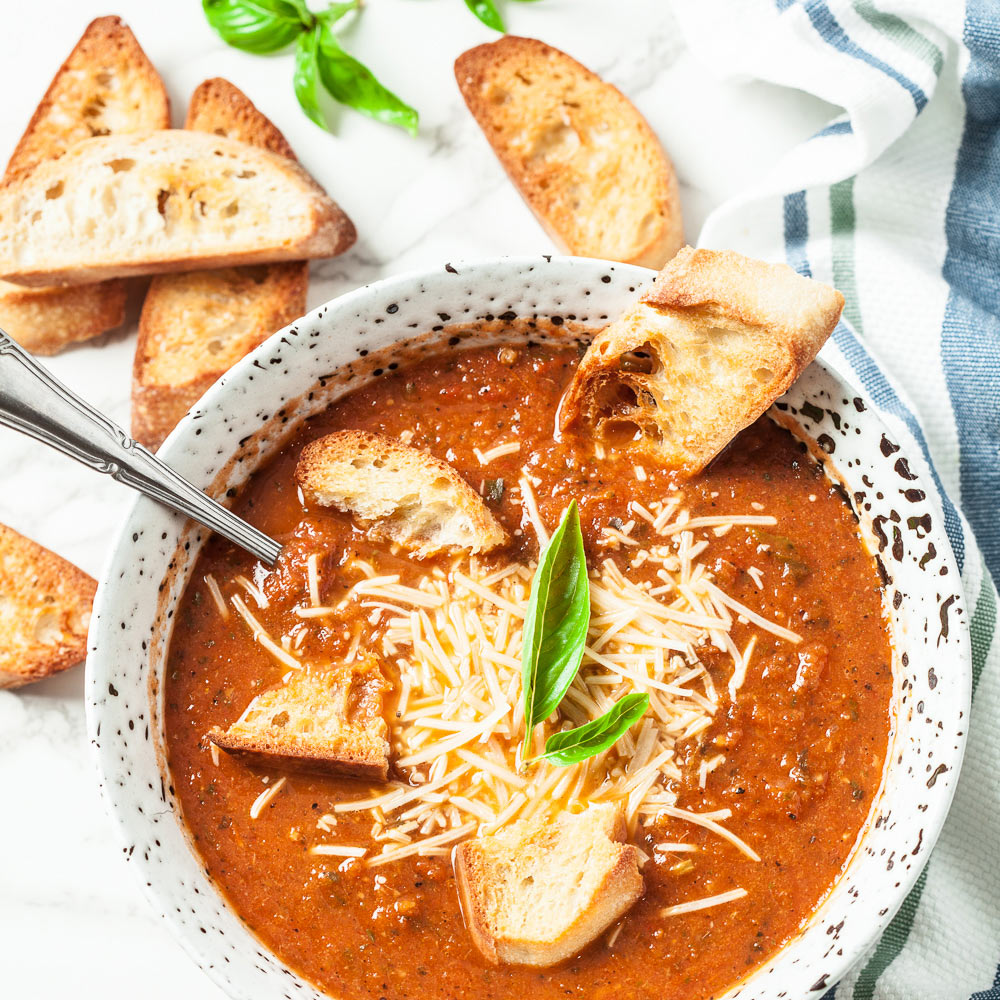 Tomato Basil Soup with Shredded Cheese and Crusty Bread