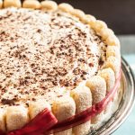 side image of tiramisu topped with cocoa powder and wrapped in a red ribbon