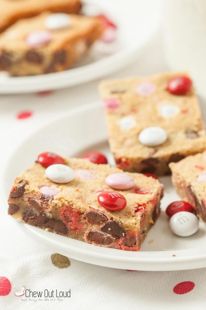 M&M chocolate cookie bars cut up in squares on a plate
