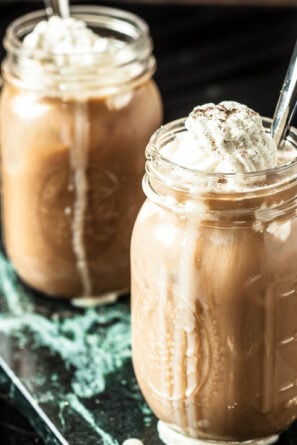 thai iced coffee with whipped cream in glass mugs