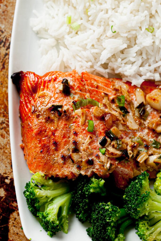 oven baked salmon with ginger soy marinade on plate with rice and broccoli