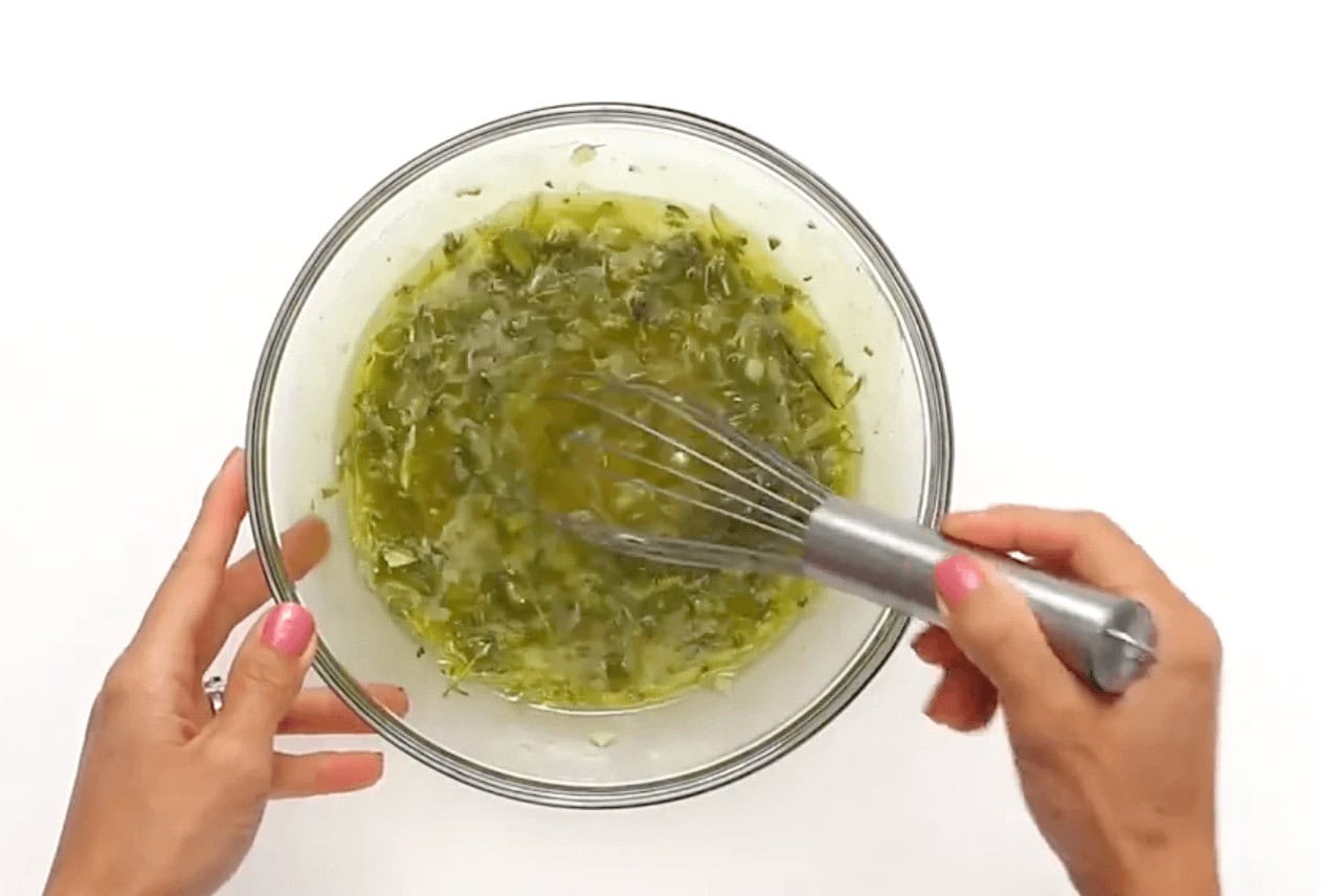 Mixing together the ingredients in a glass bowl with a whisk.