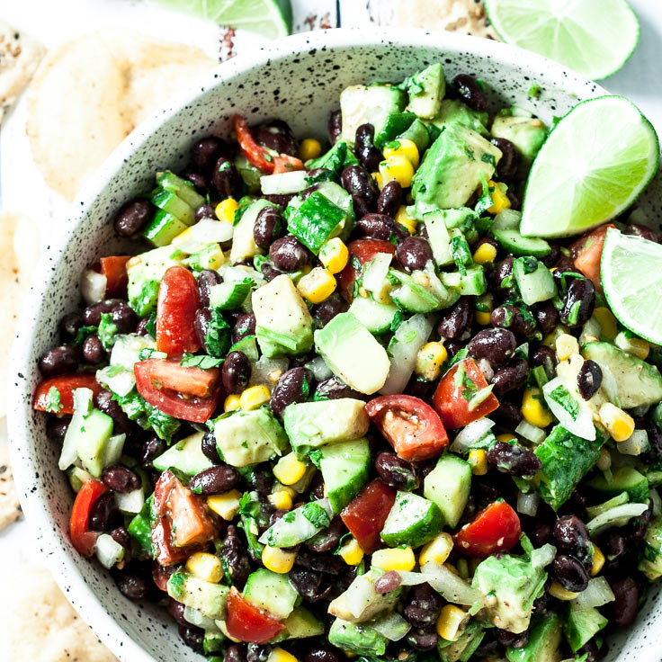 Mexican salad in a bowl with limes and chips