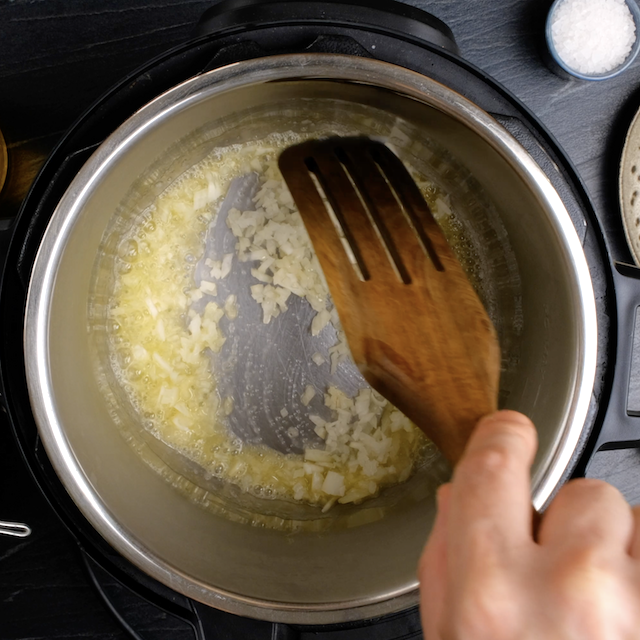 Onions being sautéed in butter to make instant pot risotto.