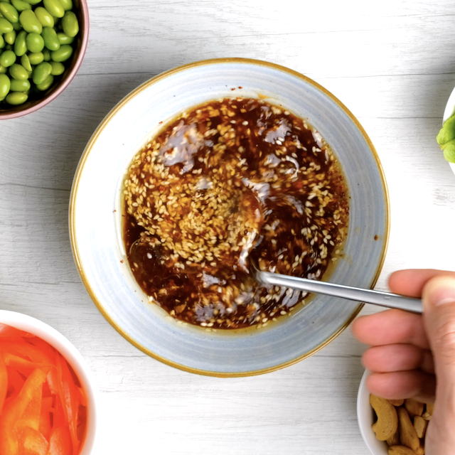 Vietnamese chicken salad dressing ingredients being whisked together in a bowl using a fork.