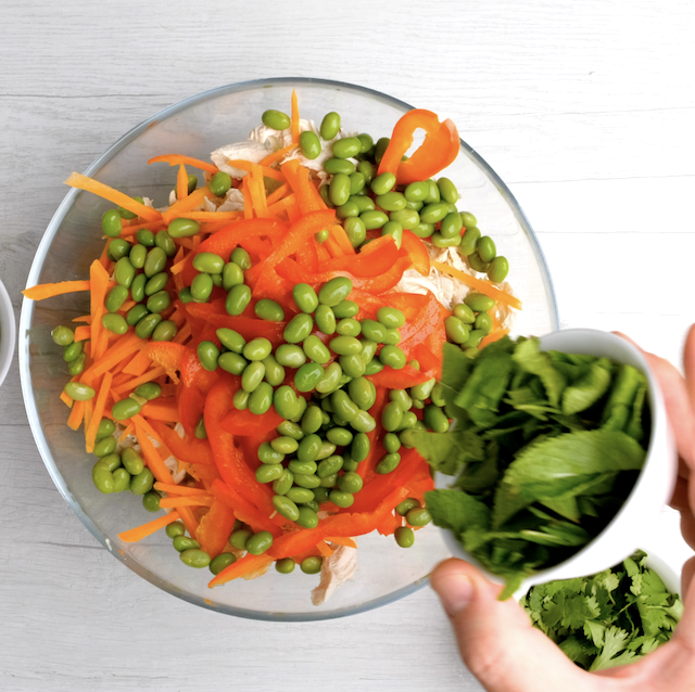 Vietnamese chicken salad vegetables being combined in a salad bowl.