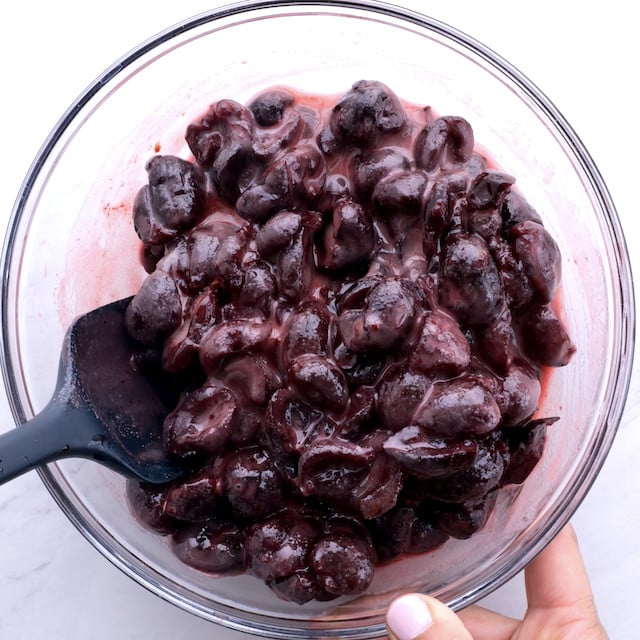 A glass bowl with cherry pie filling mixture to make sweet cherry pie at home.