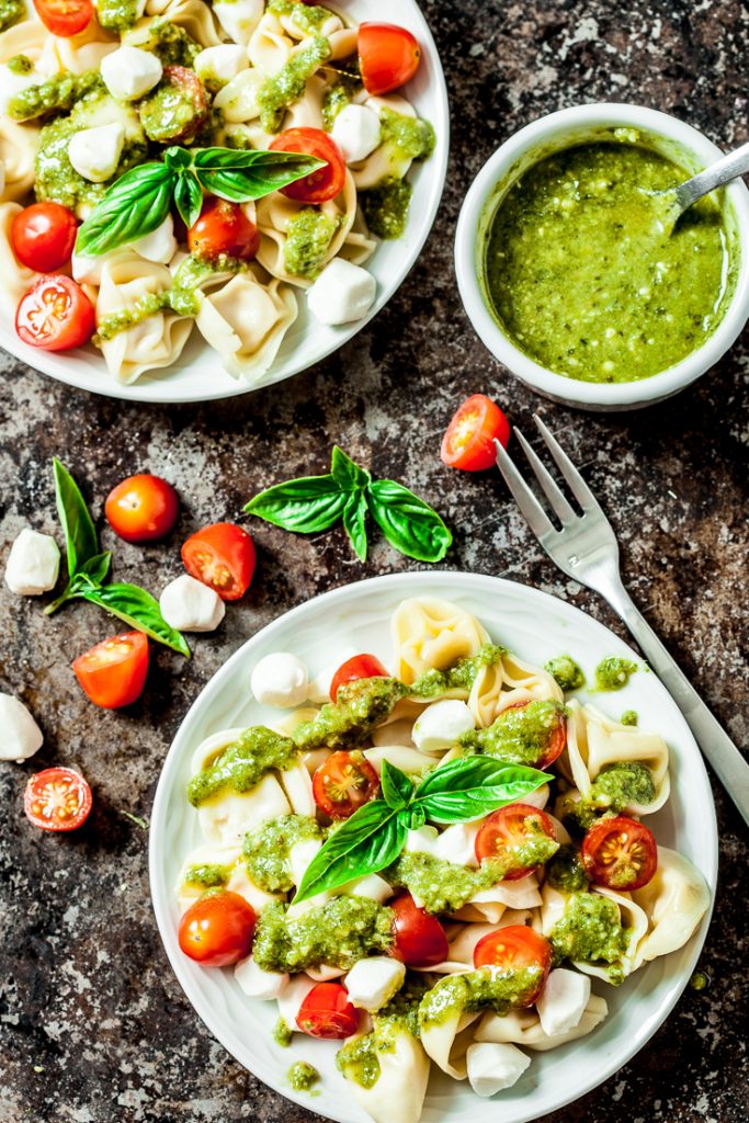 tortellini pasta salad with pesto sauce, tomatoes, and mozzarella