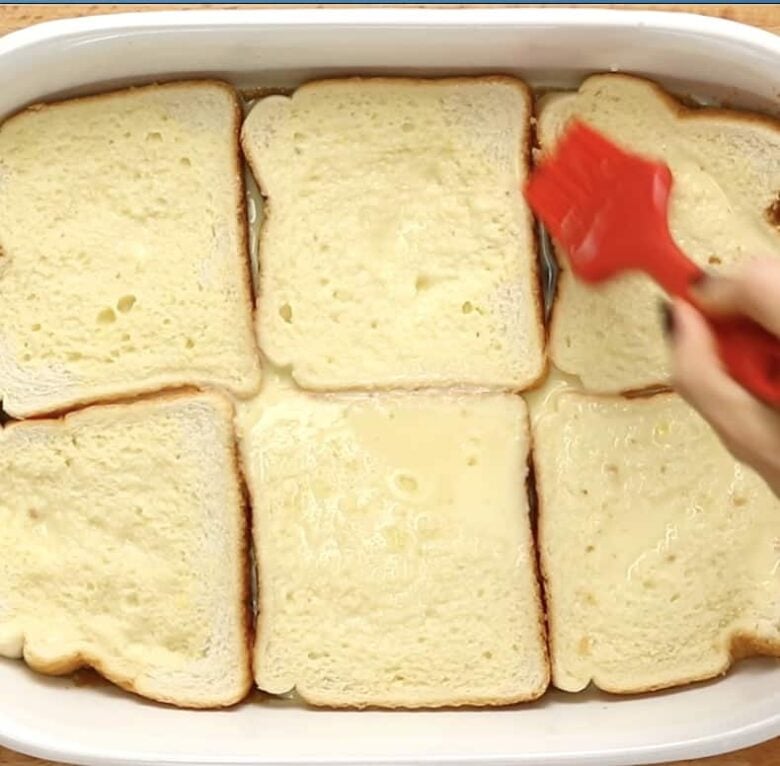 French Toast Casserole Brushing Custard Onto Bread.