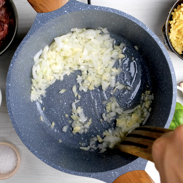 Onions and garlic being sautéed in a pot.