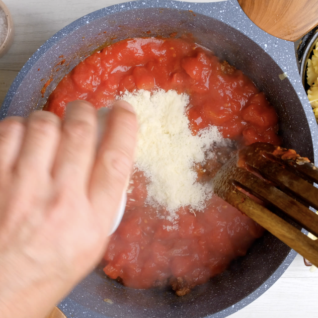 Parmesan being added to pot with easy lasagna soup base.