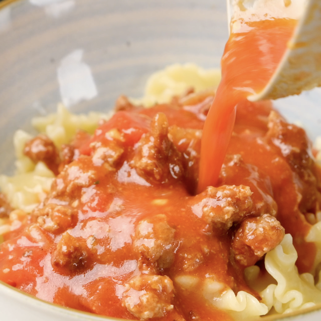 Soup being poured over pasta to make easy lasagna soup.