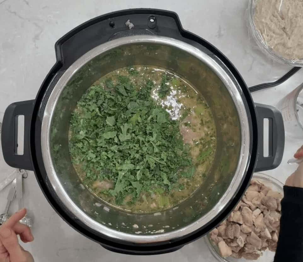 Adding the chopped kale into the Instant Pot.