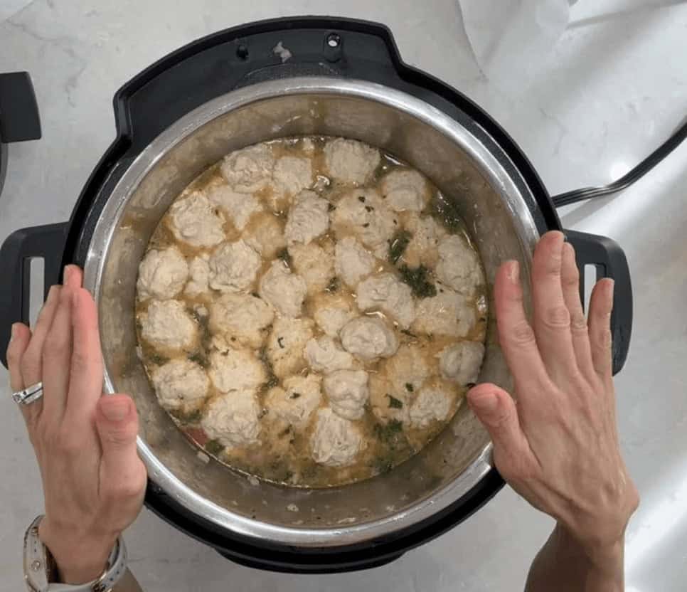 Dropping the dumpling dough into the Instant Pot.