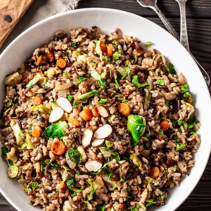 wild rice pilaf in a white bowl with slivered almonds on top