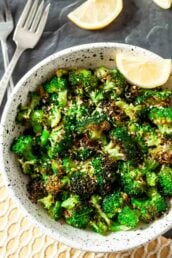 Air Fryer Broccoli in a bowl with fork and lemon slices for garnish.