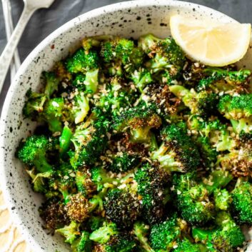 Air Fryer Broccoli in a bowl with fork and lemon slices for garnish.