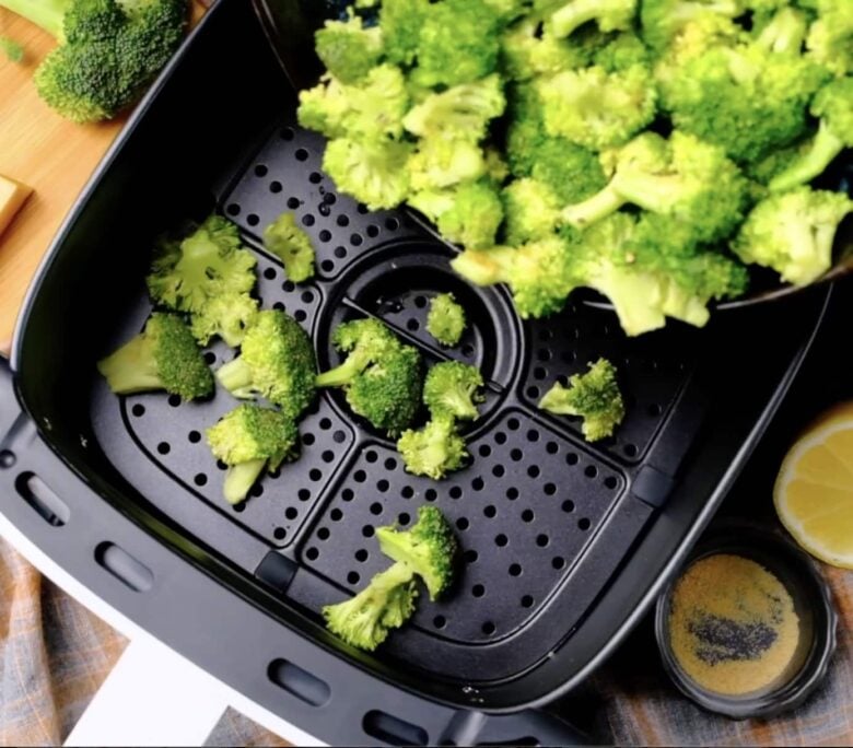 Broccoli florets placed in a single layer in bottom of air fryer basket. 